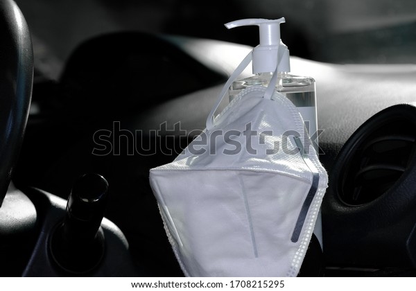 Hygienic masks hanging on hand sanitizer gel for\
hand hygien the inside of the car. For hygiene corona virus\
COVID1-9 cleaning protection before and after coming back to the\
car. COVID-19 concept