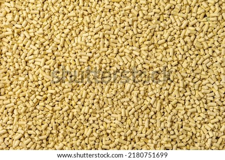 Hygienic natural clumping cat litter. Texture of vegetable fiber granules. Yellow corn tofu close up.