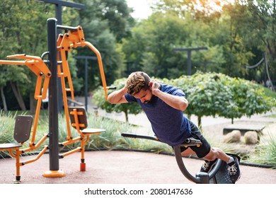 Hyperextension exercise. Charismatic man trains at the open air gym. Outdoor fitness background. - Shutterstock ID 2080147636
