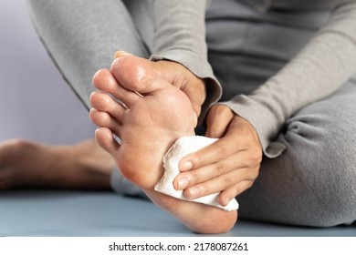 Hyperhidrosis, The woman wipes her feet after they have been excessively perspiring. - Shutterstock ID 2178087261