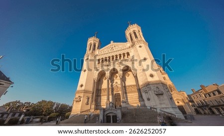 Hyperlapse front view of the Basilica of Notre Dame de Fourviere during sunset in Lyon, France. This iconic minor basilica is illuminated with warm light, overlooking the city from a hilltop timelapse