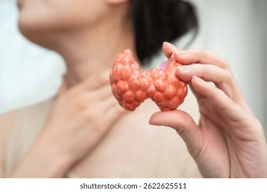 Hyperthyroidism, Overactive Thyroid, Thyroid Lymphoma, Asian woman with thyroid gland human anatomy model.
