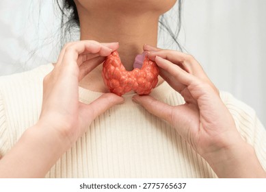 Hyperthyroidism, Overactive Thyroid, Thyroid Lymphoma, Asian woman with thyroid gland human anatomy model.