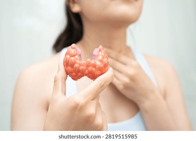 Hyperthyroidism, Overactive Thyroid, Thyroid Lymphoma, Asian woman with thyroid gland human anatomy model.