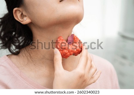 Hyperthyroidism, Overactive Thyroid, Thyroid Lymphoma, Asian woman with thyroid gland human anatomy model.