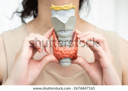 Hyperthyroidism, Overactive Thyroid, Thyroid Lymphoma, Asian woman with thyroid gland human anatomy model.