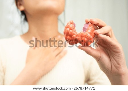 Hyperthyroidism, Overactive Thyroid, Thyroid Lymphoma, Asian woman with thyroid gland human anatomy model.