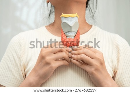 Hyperthyroidism, Overactive Thyroid, Thyroid Lymphoma, Asian woman with thyroid gland human anatomy model.