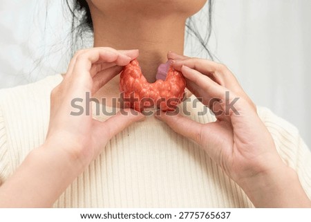 Hyperthyroidism, Overactive Thyroid, Thyroid Lymphoma, Asian woman with thyroid gland human anatomy model.