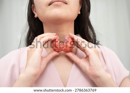 Hyperthyroidism, Overactive Thyroid, Thyroid Lymphoma, Asian woman with thyroid gland human anatomy model.