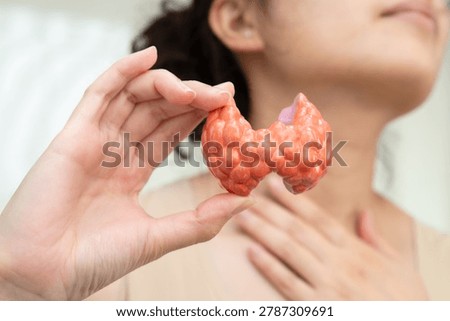 Hyperthyroidism, Overactive Thyroid, Thyroid Lymphoma, Asian woman with thyroid gland human anatomy model.