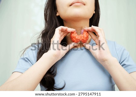 Hyperthyroidism, Overactive Thyroid, Thyroid Lymphoma, Asian woman with thyroid gland human anatomy model.