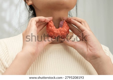 Hyperthyroidism, Overactive Thyroid, Thyroid Lymphoma, Asian woman with thyroid gland human anatomy model.