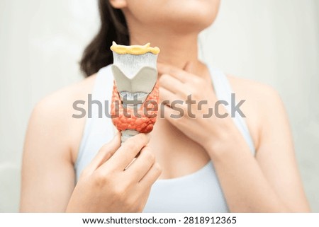 Hyperthyroidism, Overactive Thyroid, Thyroid Lymphoma, Asian woman with thyroid gland human anatomy model.