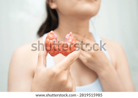 Hyperthyroidism, Overactive Thyroid, Thyroid Lymphoma, Asian woman with thyroid gland human anatomy model.