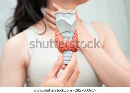 Hyperthyroidism, Overactive Thyroid, Thyroid Lymphoma, Asian woman with thyroid gland human anatomy model.