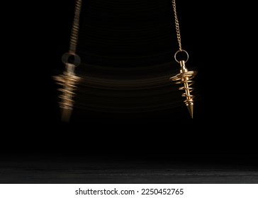 Hypnosis session. Pendant swinging over surface on black background, motion effect - Powered by Shutterstock