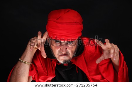 Hypnotist or sorcerer is doing hypnosis or magic with eyes and hands
