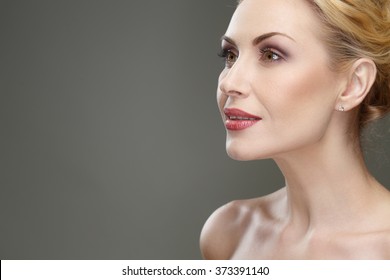 Hypnotized. Cropped Studio Closeup Of A Beautiful Mature Woman Looking Attentively Smiling