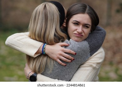 Hypocritical girl hugs a friend but gets bored of being close to her. Fake Friendship concept - Shutterstock ID 2244814861