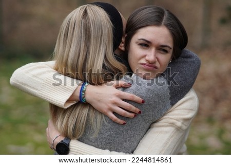 Hypocritical girl hugs a friend but gets bored of being close to her. Fake Friendship concept