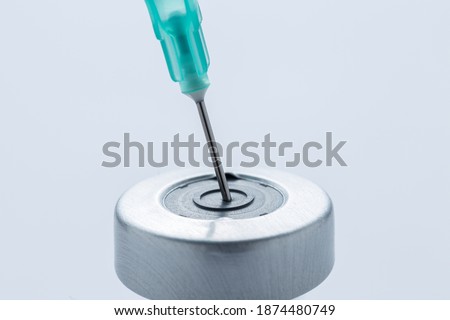A hypodermic needle inside of a vial containing a vaccine