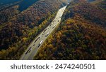 I-40 freeway in North Carolina leading to Asheville through Appalachian mountains in golden fall with fast moving trucks and cars. Interstate transportation concept