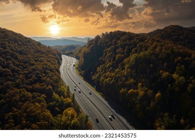 I-40 freeway road leading to Asheville in North Carolina thru Appalachian mountains with yellow fall forest and fast moving trucks and cars. Concept of high speed interstate transportation - Powered by Shutterstock