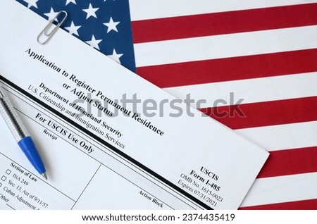 I-485 Application to register permanent residence or adjust status blank form lies on United States flag with blue pen from Department of Homeland Security close up