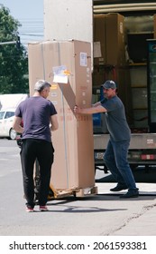 Iasi, Romania, 7th June 2021: Two Middle Aged Men Carrying A Big Box