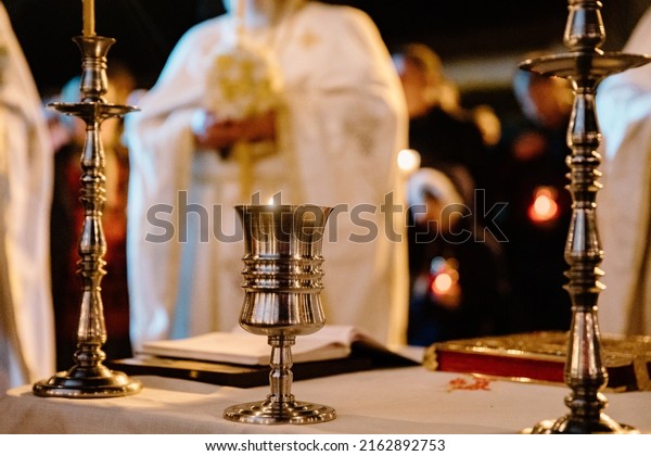 Iasi, Romania - April 24 2022: Detail of a holy\
candle during orthodox Easter religious service that takes place in\
front of the church, at midnight, celebrating the resurrection of\
Jesus Christ.