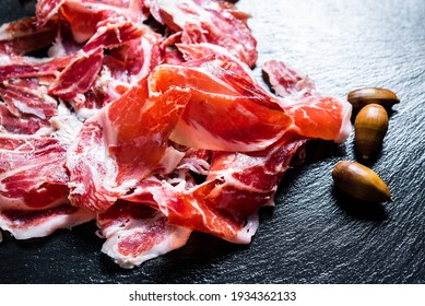 Iberian Ham. acorn-fed Iberian ham. Portion of Iberian ham on slate - Shutterstock ID 1934362133