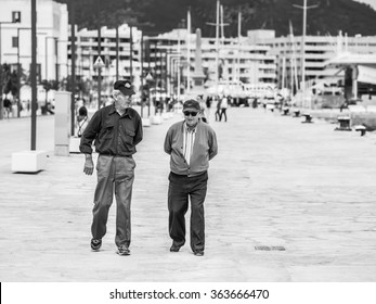 IBIZA, SPAIN - MAY 24, 2015. Two Old Men Talking And Walking In The Ibiza Harbor.