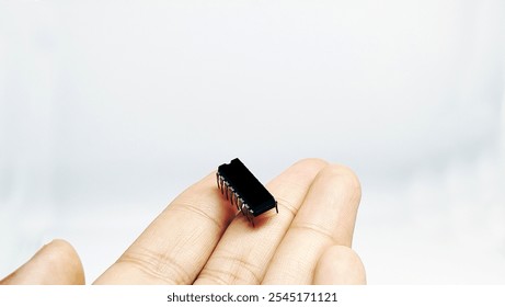 IC or integrated circuit is an integrated electronic component that functions to process, control and manipulate electronic devices, closeup with hand 16 pin
