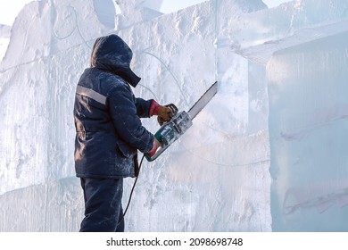 An Ice Ax Artist Carves An Ice Sculpture With A Chainsaw. New Year's Holiday Activities.