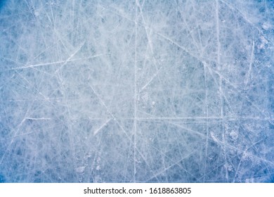 Ice background with marks from skating and hockey, blue texture of rink surface with scratches