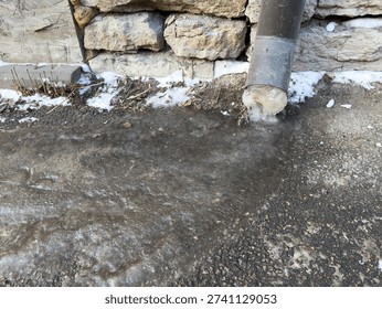 Ice block at base of drainpipe after freeze thaw cycle