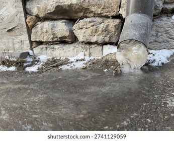 Ice block at base of drainpipe after freeze thaw cycle