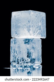Ice blocks in a cube form, stacked on a mirror surface on black background. - Shutterstock ID 2223492647