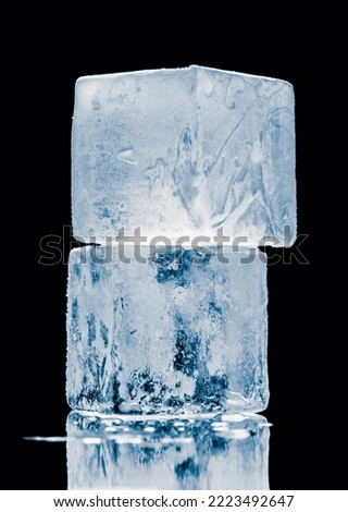 Ice blocks in a cube form, stacked on a mirror surface on black background.