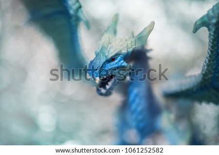 Ice blue dragon toy photo on blur bokeh background, winter cool colors tone