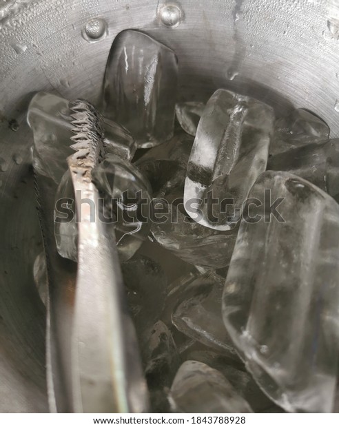 Ice bucket,Metal bucket with\
pieces of ice,Ice cube is very cold in bucket ready to\
serve.