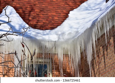 Ice build up in roof gutters creating a dam against drainage. - Shutterstock ID 1366725461