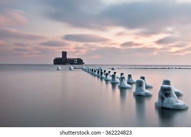 Ice Caps On Old Wooden Stakes In Line And Ruins Of Torpedo Building