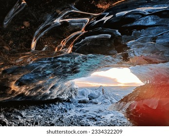 The ice cave of the Katla volcano with the sunset in the background in Iceland