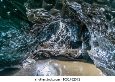 Ice cave located beneath glacier among ice mountain in Iceland, it is mesmerizing landmark. - Shutterstock ID 1051782572