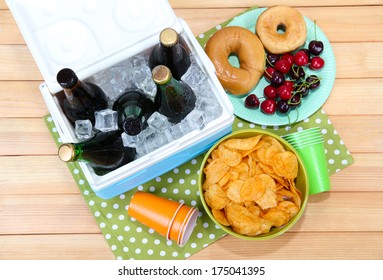 Ice Chest Full Of Drinks In Bottles On Color Napkin, On Wooden Background