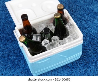 Ice Chest Full Of Drinks In Bottles On Color Carpet Background