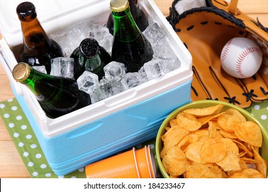 Ice Chest Full Of Drinks In Bottles On Color Napkin, On Wooden Background