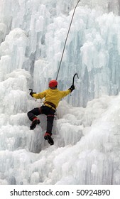 Ice Climber On Steep Frozen Waterfall